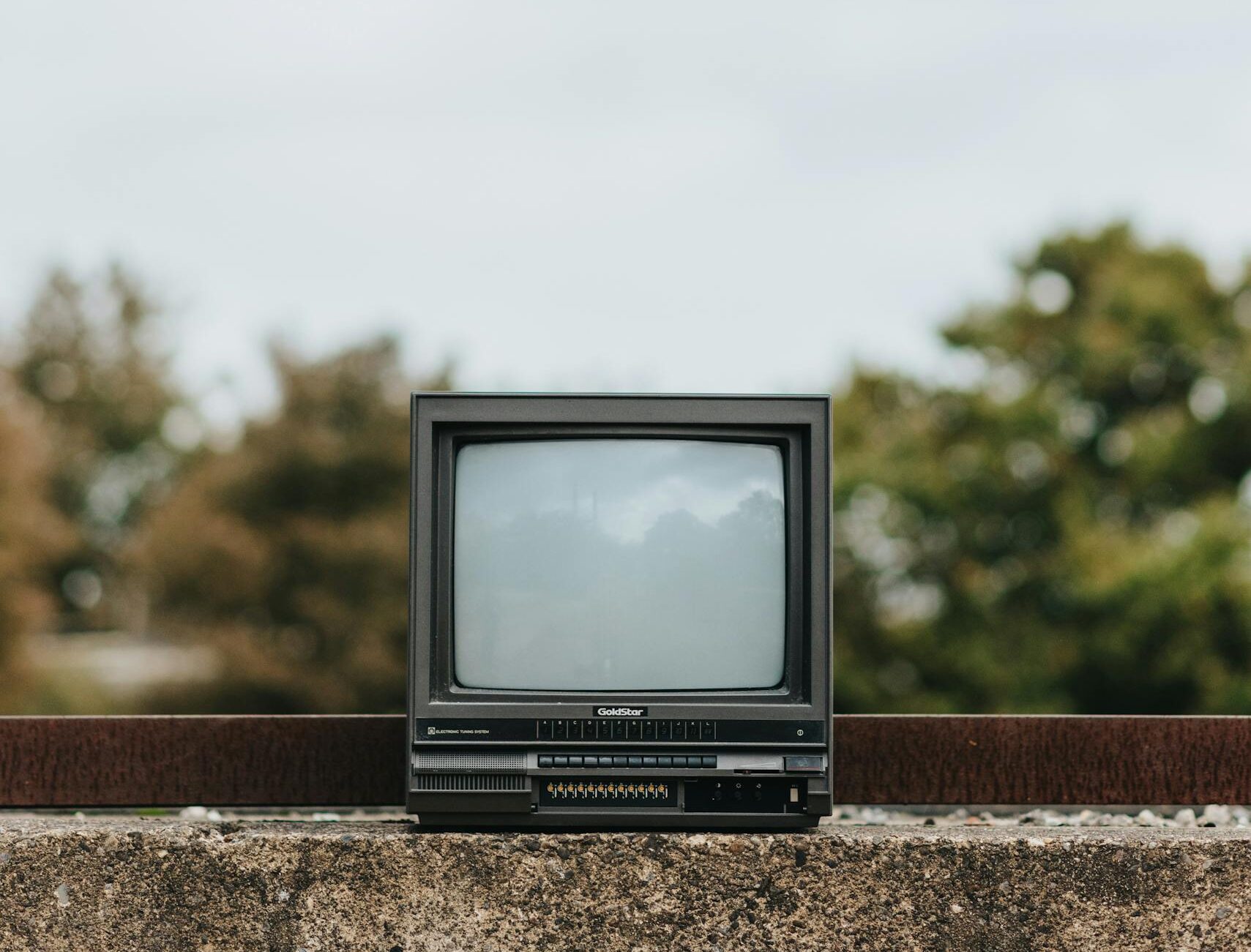 Small used TV set on concrete railing