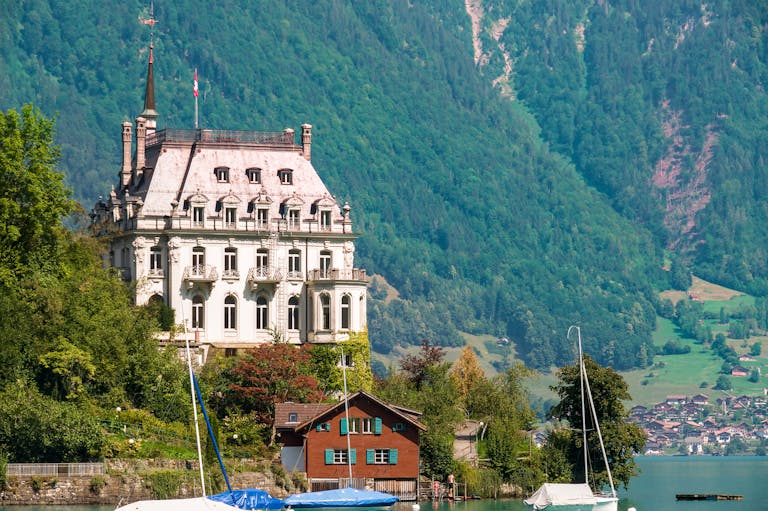 A picturesque view of Seeburg Castle surrounded by lush greenery and Lake Brienz.