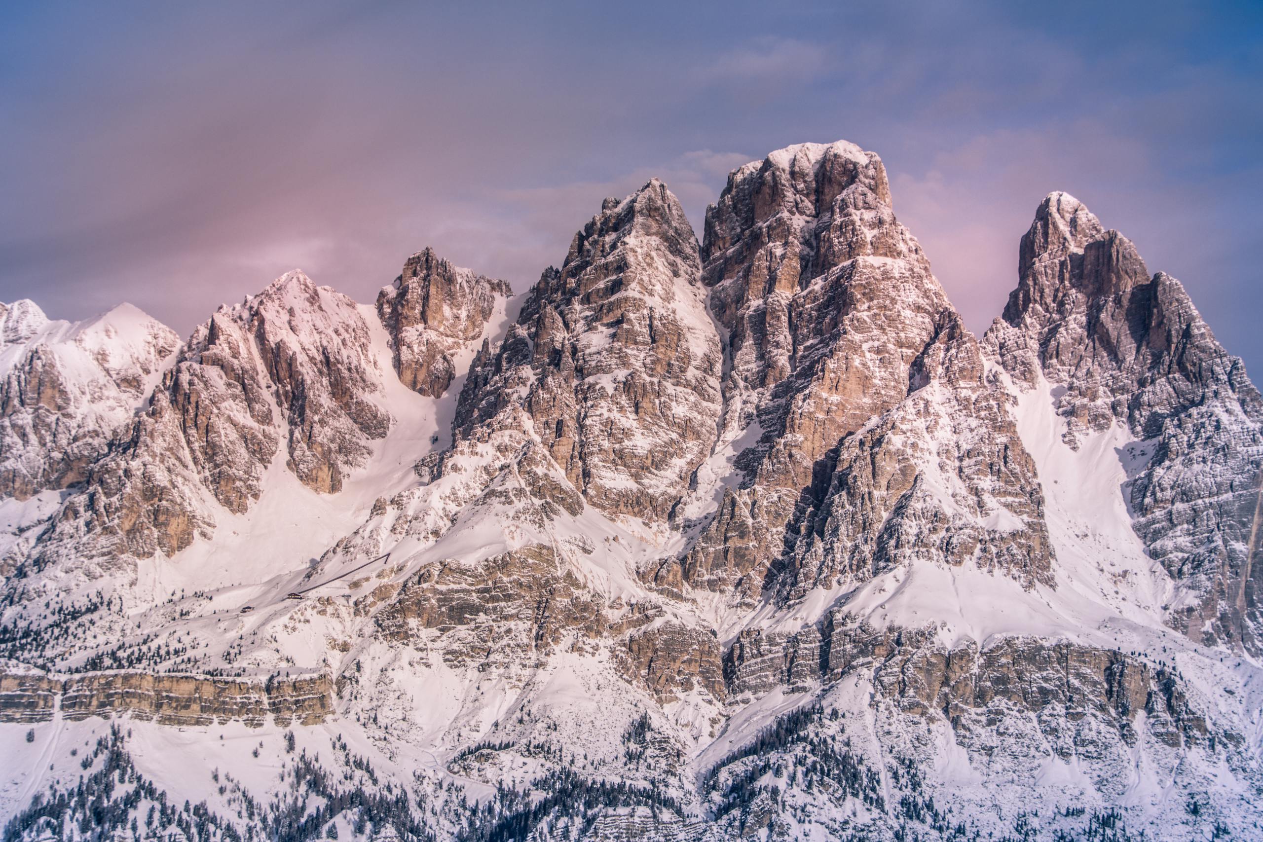 Breathtaking view of the Dolomites with snow-capped peaks during dawn, capturing the serene beauty of nature.