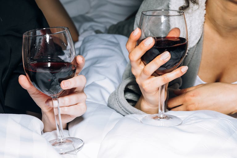 Two friends enjoying red wine in a cozy setting, perfect for a relaxing night in.